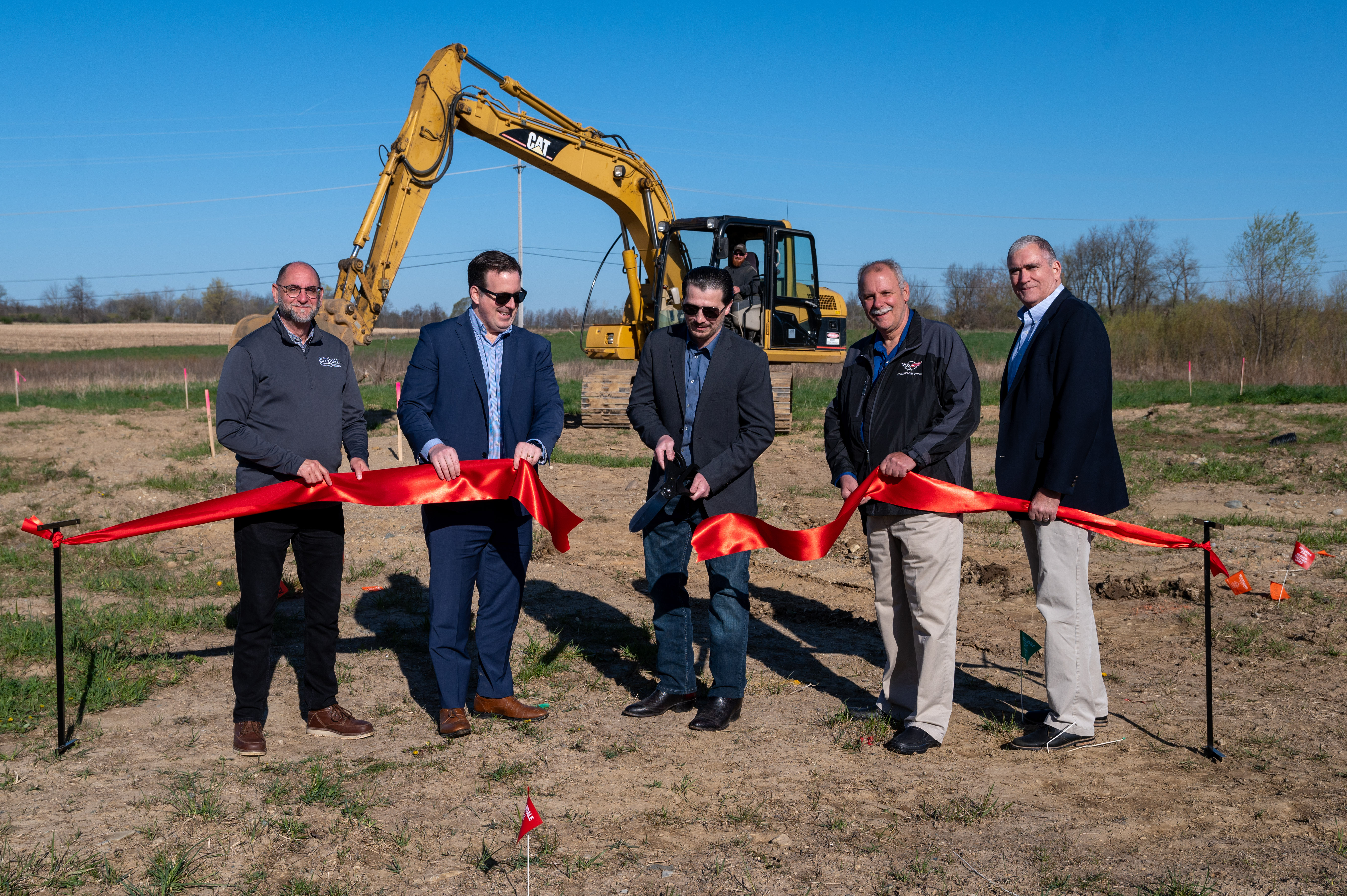 Hillsdale Mayor Adam Stockford cuts a ribbon at the groundbreaking ceremony for Allen Edwin Homes' workforce housing project